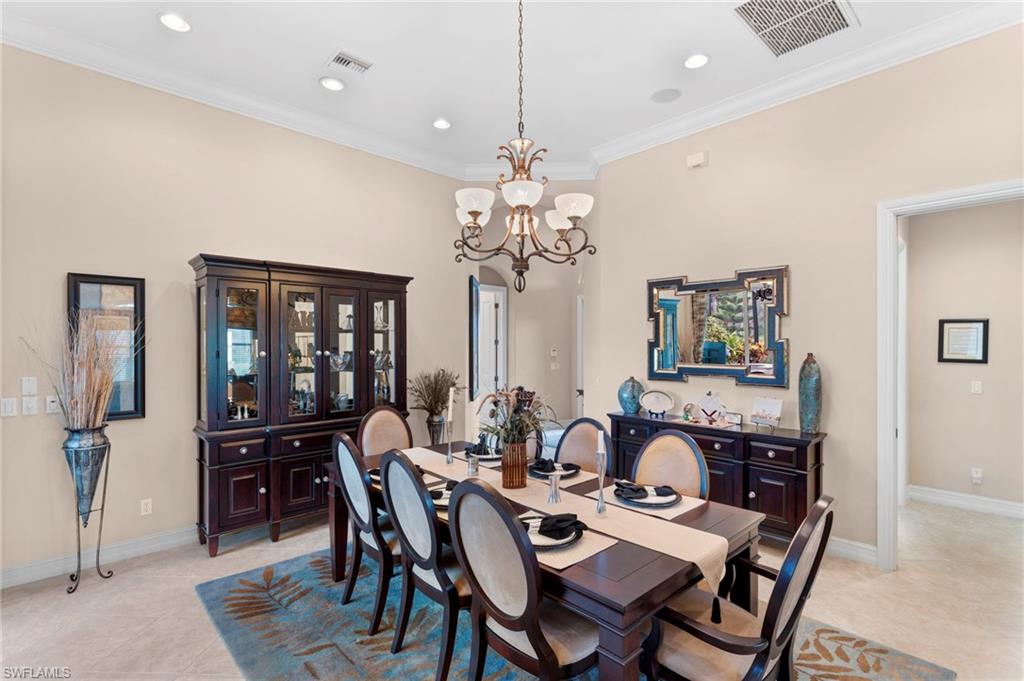 Tiled dining space with ornamental molding and a chandelier
