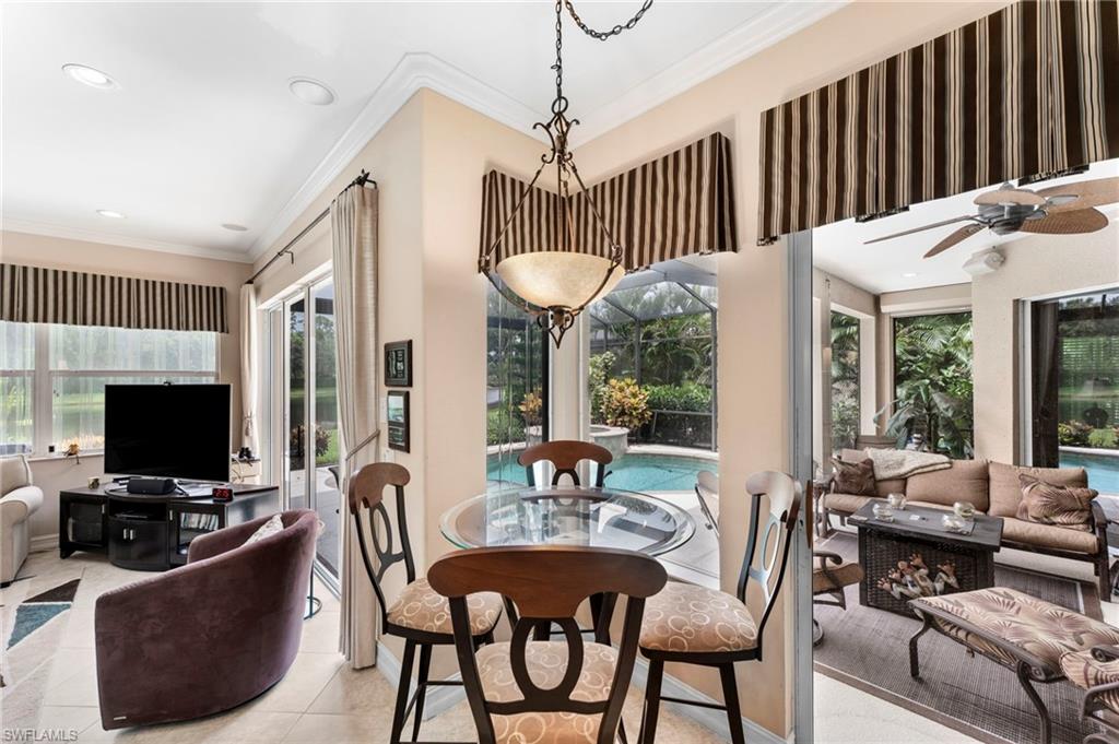 Tiled dining area with crown molding and ceiling fan
