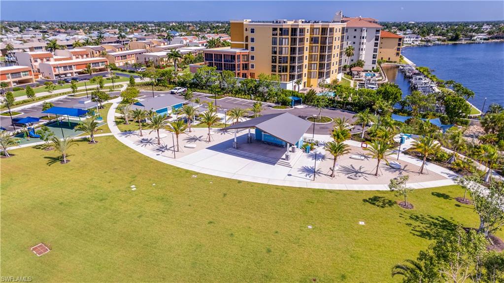 Jaycee Park-Expansive green space featuring a large central lawn, a covered gathering area with seating, and multiple mature palm trees