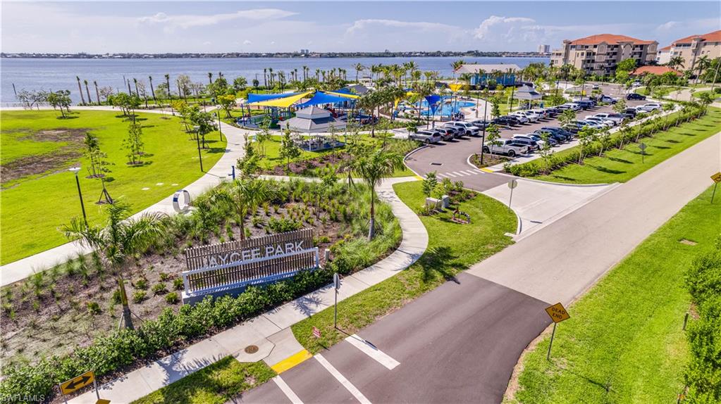 Jaycee Park-Expansive waterfront park area featuring a designated play zone, paved walking paths, abundant green space, and mature landscaping