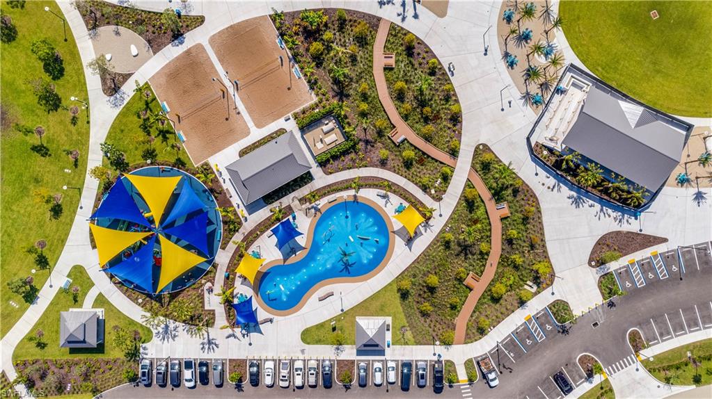 Jaycee Park-Expansive recreational area featuring a large splash pad, shaded playground, two sand volleyball courts, and a spacious parking lot