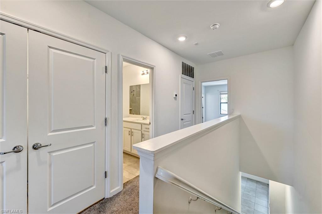 Elegant staircase with clean modern lines and neutral-toned flooring leading to the upper level of this multi-story Lake Jessup home, offering a stylish transition between floors.