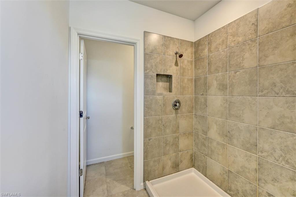 Luxurious primary bathroom featuring a large walk-in shower with stunning floor-to-ceiling tile surround, frameless glass enclosure, and upscale finishes for a spa-like experience.