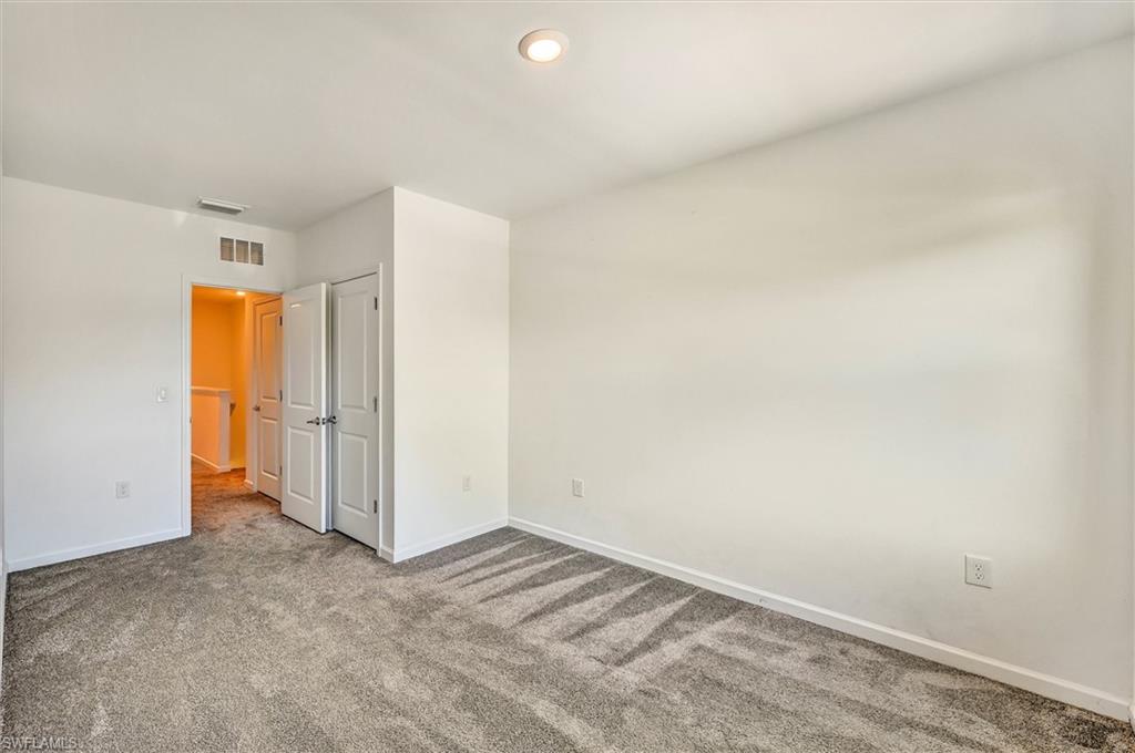 Generously sized bedroom with wood-look flooring and large windows providing abundant natural light, offering a warm and inviting atmosphere throughout.