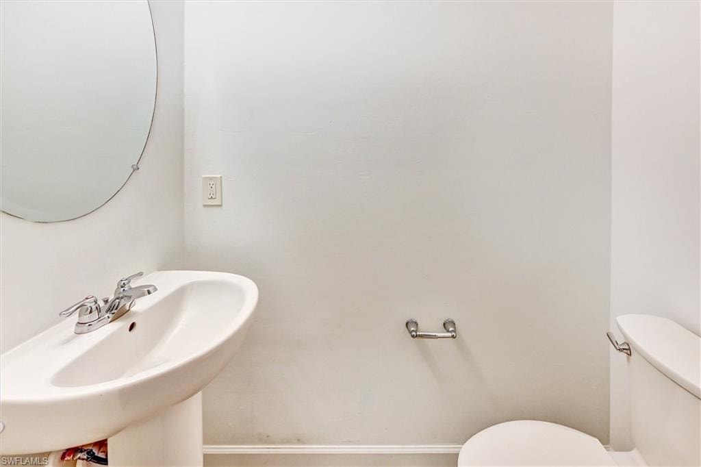 Convenient first-floor half bathroom with a pedestal sink, updated fixtures, and tasteful finishes — ideal for guests and everyday use on the main living level.