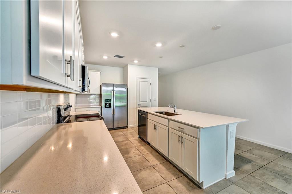 Bright and modern kitchen showcasing a large center island with seating, sleek countertops, and high-end finishes — a dream kitchen for cooking and gathering.