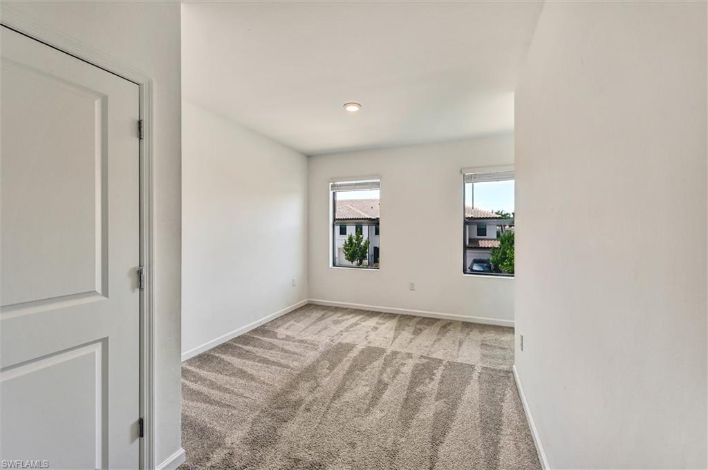 Bright and spacious bedroom featuring large windows, wood-look flooring, and a clean modern aesthetic — a peaceful retreat within this stunning Lake Jessup home.