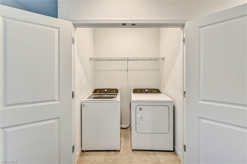 Dedicated laundry room with side-by-side washer and dryer included, built-in cabinetry, and ample space for storage and utility needs — a practical and convenient home feature.