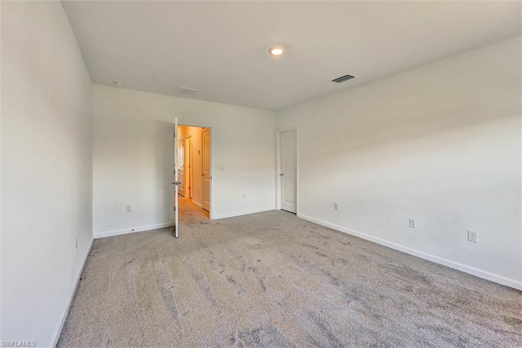 Well-proportioned bedroom with large windows, neutral carpet flooring, and room for a full or queen bedroom set — ideal for family members or overnight guests.