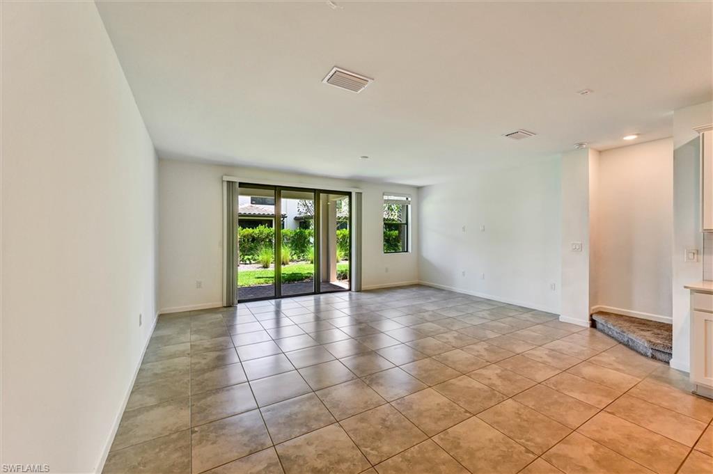 Open and airy great room at 1519 Lake Jessup bathed in natural light with glass doors leading to the backyard, neutral tones, and a versatile layout ideal for both relaxing and entertaining.
