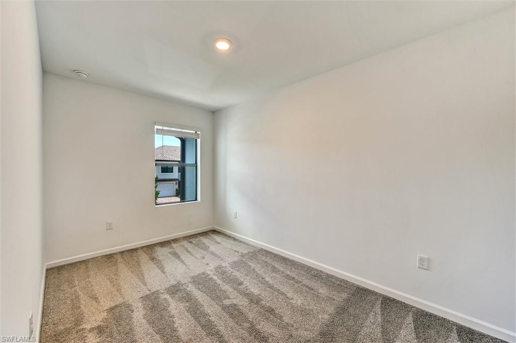 Comfortable bedroom with plush carpet, natural light from large windows, and a neutral palette — ready for your personal touch and furnishings.