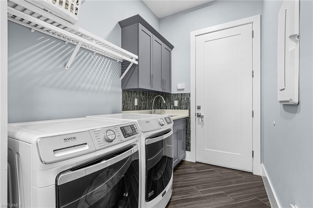 Laundry room featuring tile flooring, built-in cabinetry, an integrated sink, a tiled backsplash, and an overhead storage shelf