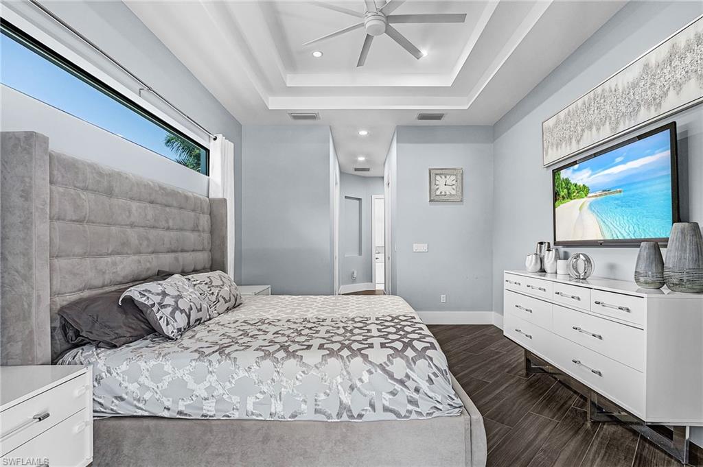 Tray ceiling with recessed lighting and a contemporary ceiling fan