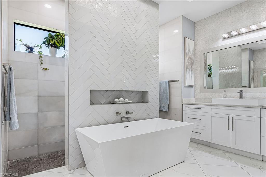 Contemporary bathroom featuring a freestanding soaking tub, a dual vanity with undermount sinks, and a walk-in shower