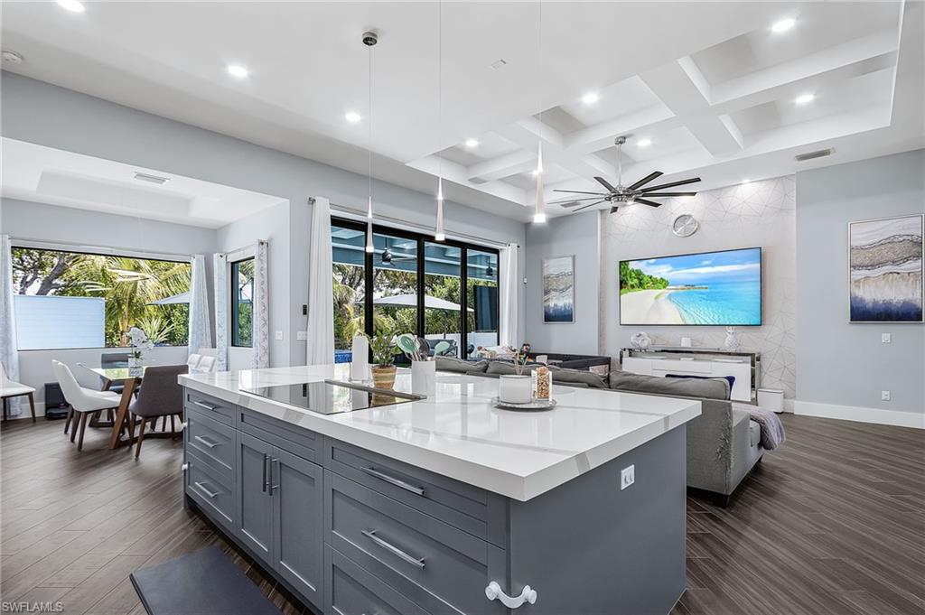 Central kitchen island featuring a light-toned countertop, gray cabinetry, and an integrated cooktop