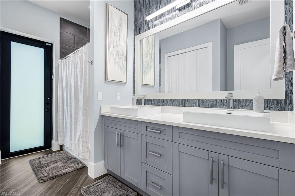 Dual rectangular vessel sinks atop a spacious vanity with shaker-style gray cabinetry and contemporary hardware