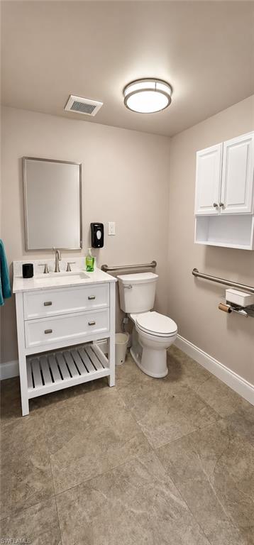 Bathroom featuring a white vanity with a rectangular basin sink, chrome faucet, and integrated storage