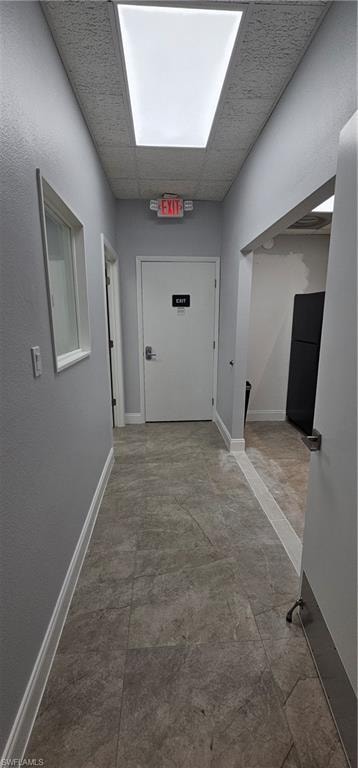 Recessed ceiling light panel, textured acoustic ceiling, light gray wall paint, white trim, and gray tile flooring