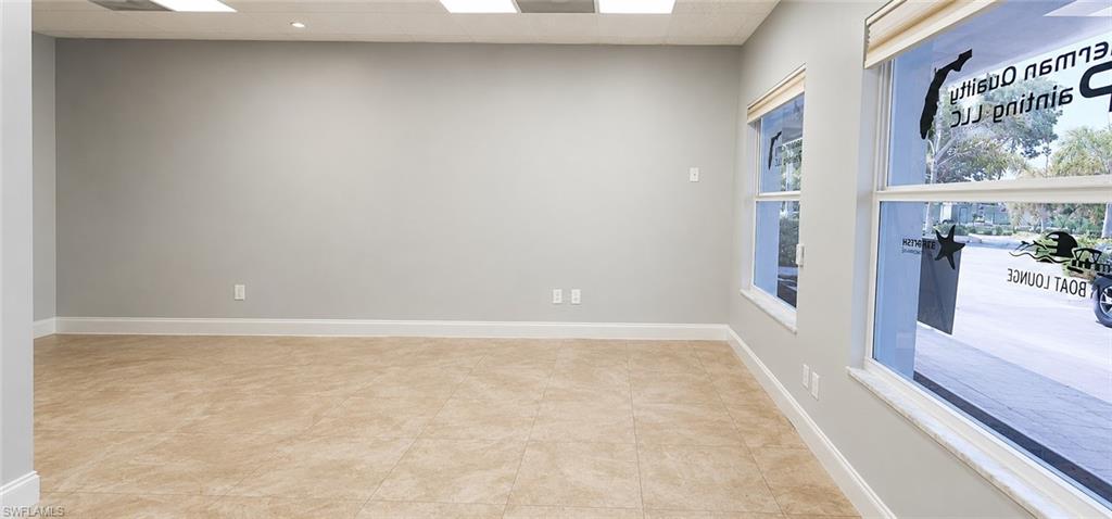 Spacious room featuring neutral wall paint, tiled flooring, recessed lighting, and multiple windows with blinds