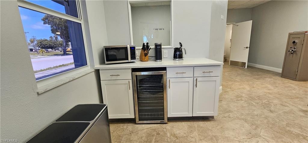 Built-in cabinetry with a white countertop and under-counter beverage cooler