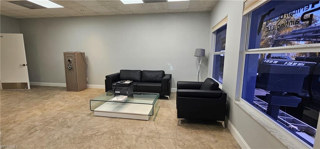 Recessed lighting, light gray wall finish, two large windows, white trim, and tiled flooring
