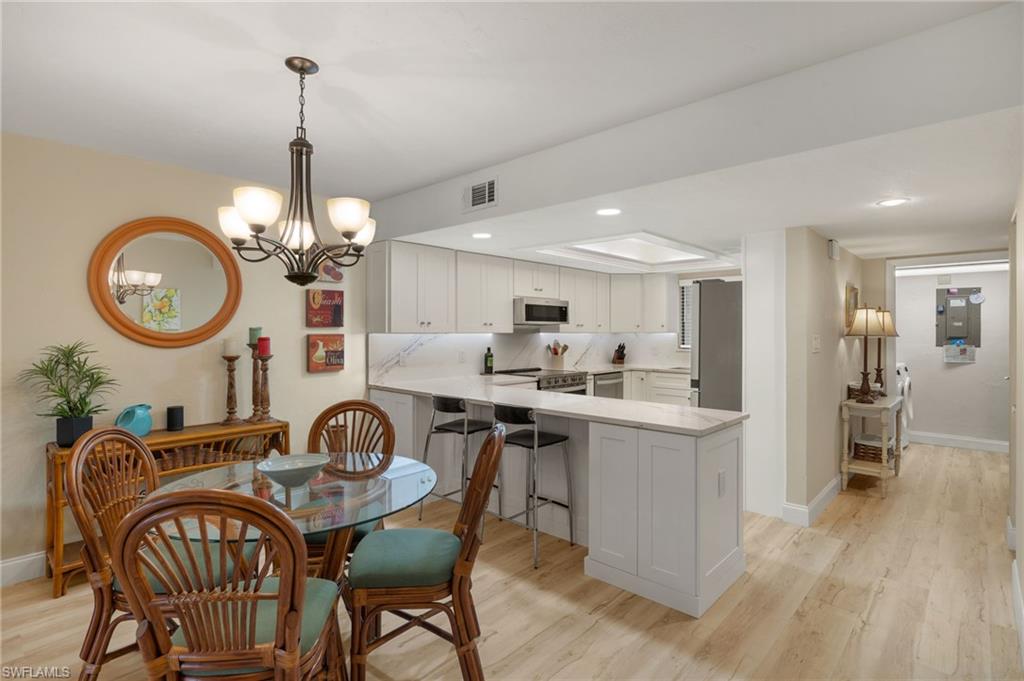 Dining area with an inviting chandelier and light hardwood / wood-style flooring