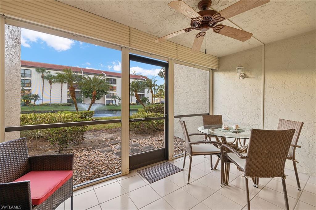 Sunroom / solarium featuring ceiling fan and a water view