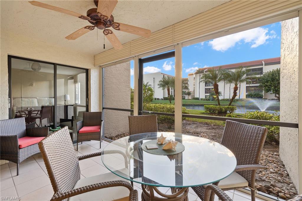 Sunroom / solarium featuring ceiling fan and a water view