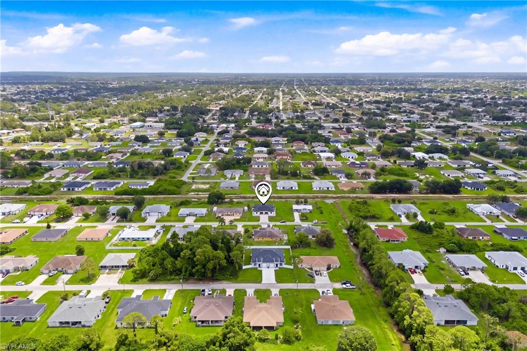 Bird’s-eye view highlighting the oversized lot, canal backdrop, and surrounding residential neighborhood setting.