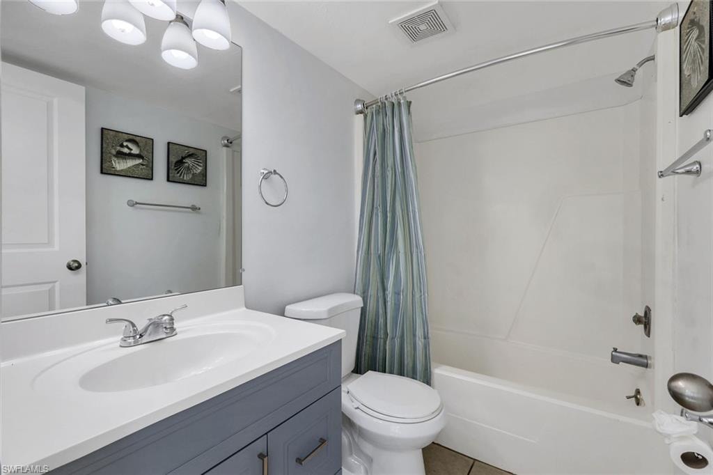Modern bathroom featuring a dual-sink vanity with soft-close cabinetry in charcoal finish, white quartz countertop, and chrome faucet fixtures