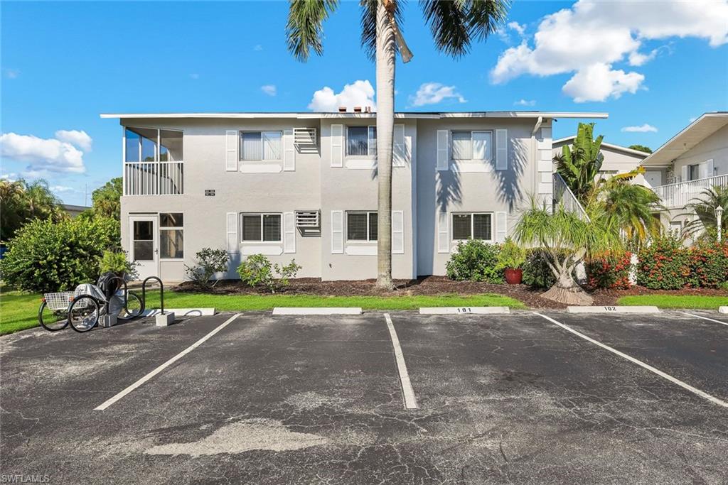 Two-story stucco exterior with white window shutters