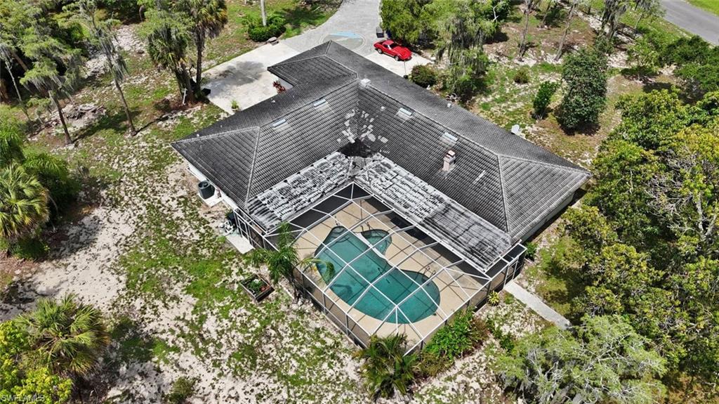 Single-story residence featuring a hip roof, an enclosed swimming pool, and a paver driveway