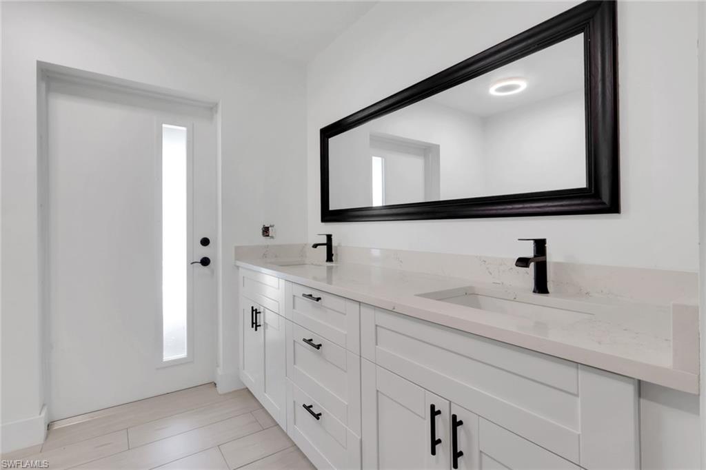 Dual vanity featuring light-toned countertops, integrated sinks, and matte black fixtures