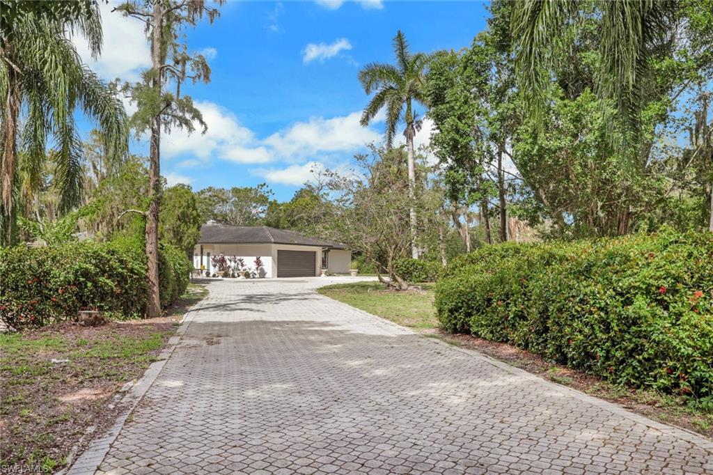 Paver driveway leading to a residence with a two-car garage
