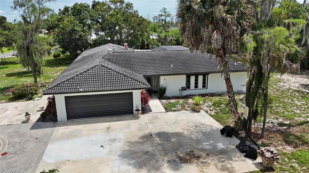 Single-story residence featuring a dark tile roof and a white exterior