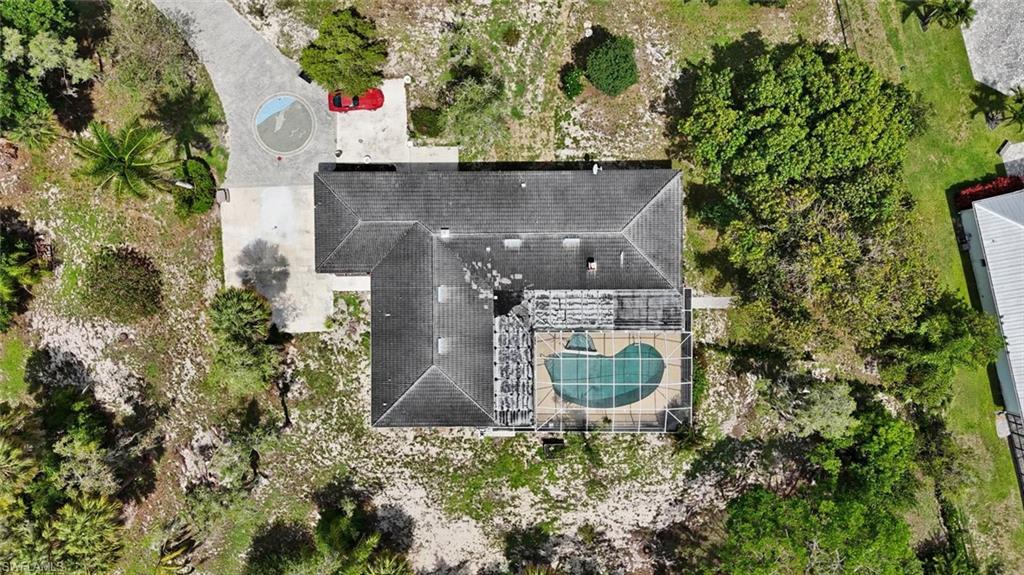 Residential property featuring a screened-in swimming pool, a circular drive, and a gabled roof