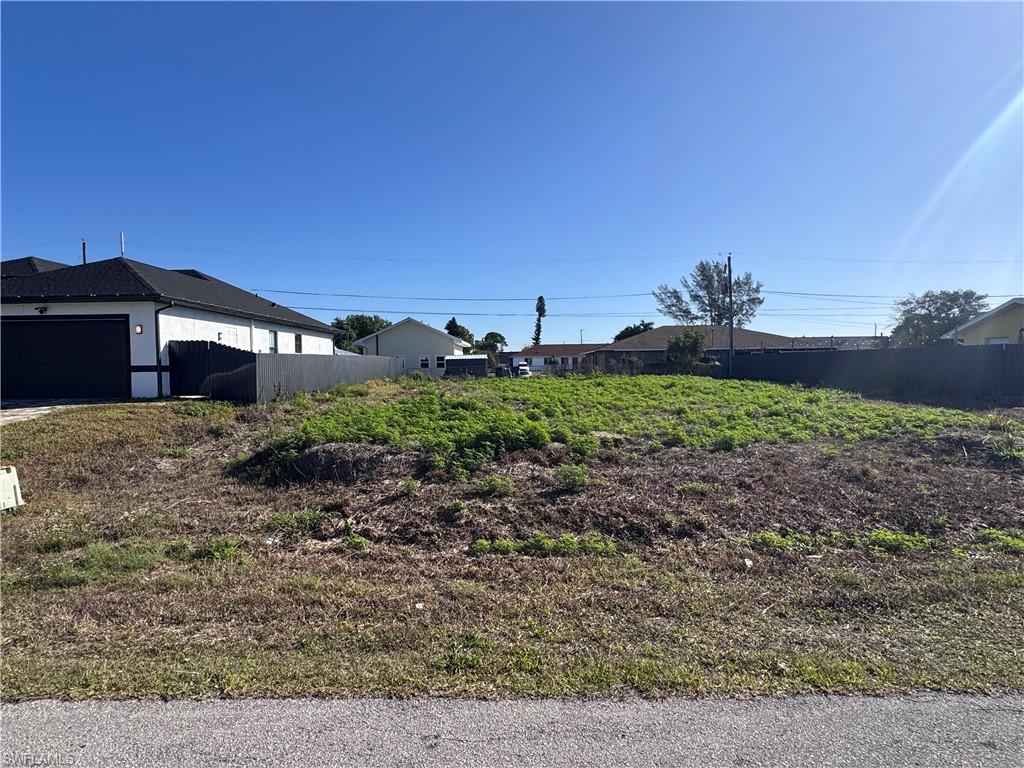 Vacant land parcel featuring a clear expanse of ground and surrounding privacy fencing