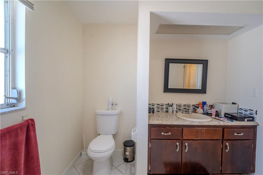 2nd bathroom featuring a white toilet, tiled flooring, and a window with horizontal blinds