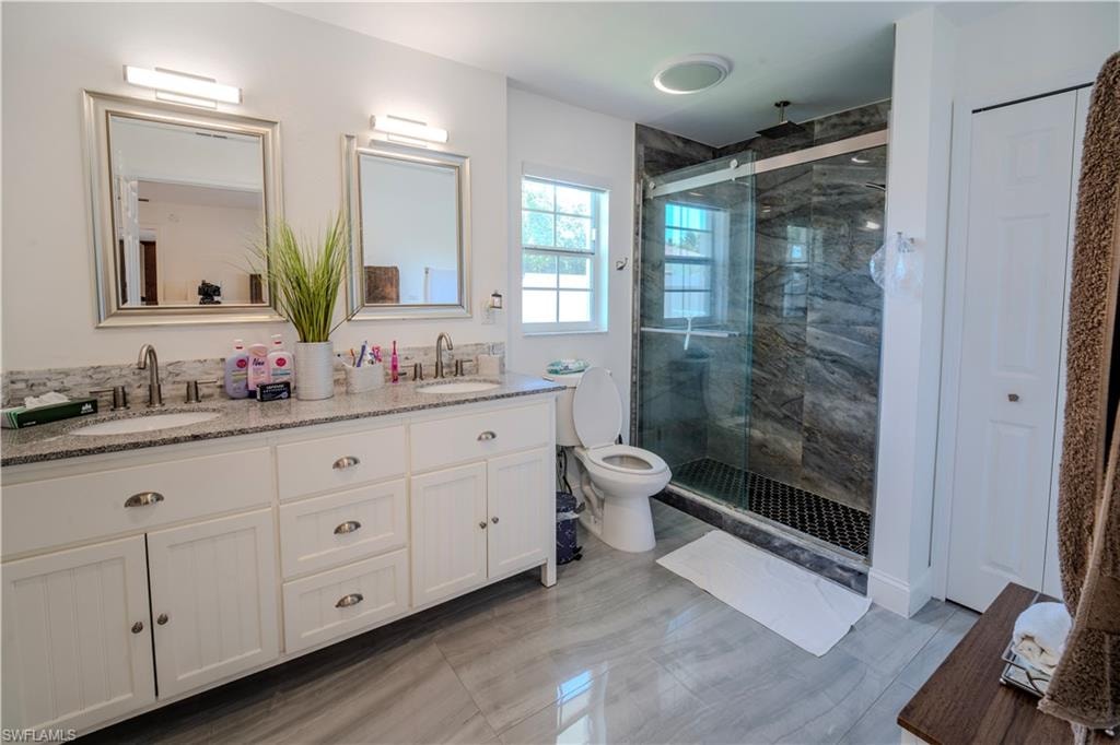 Master bathroom featuring a dual vanity with a granite countertop, undermount sinks, and brushed nickel fixtures