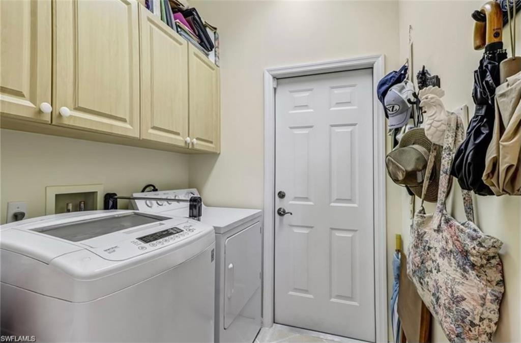 Laundry area with cabinets, separate washer and dryer, and light tile patterned floors