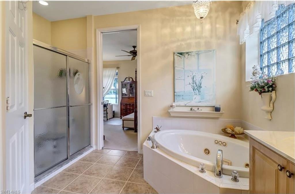 Bathroom featuring tile patterned flooring, plenty of natural light, ceiling fan, and vanity