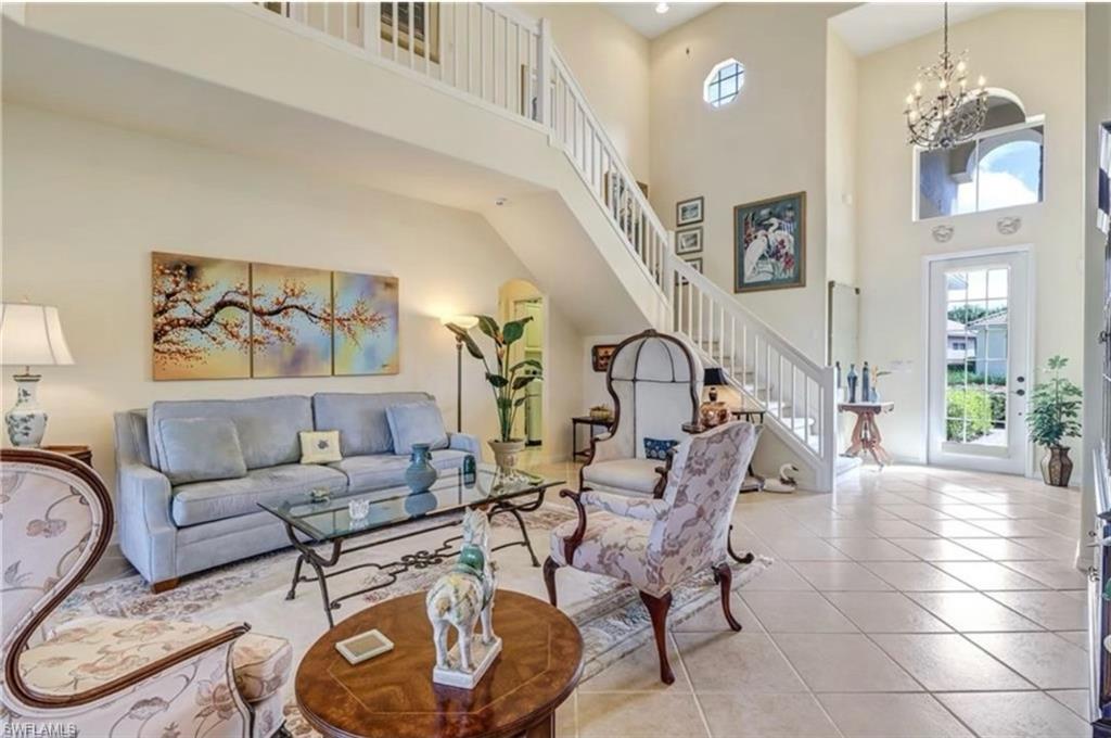 Tiled living room featuring a chandelier and a towering ceiling