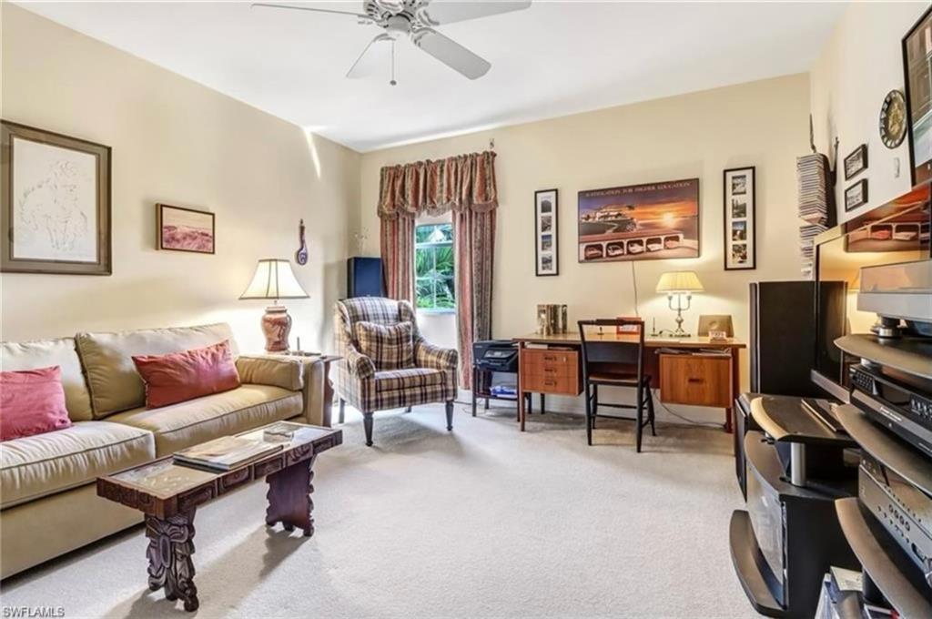 Carpeted living room with ceiling fan