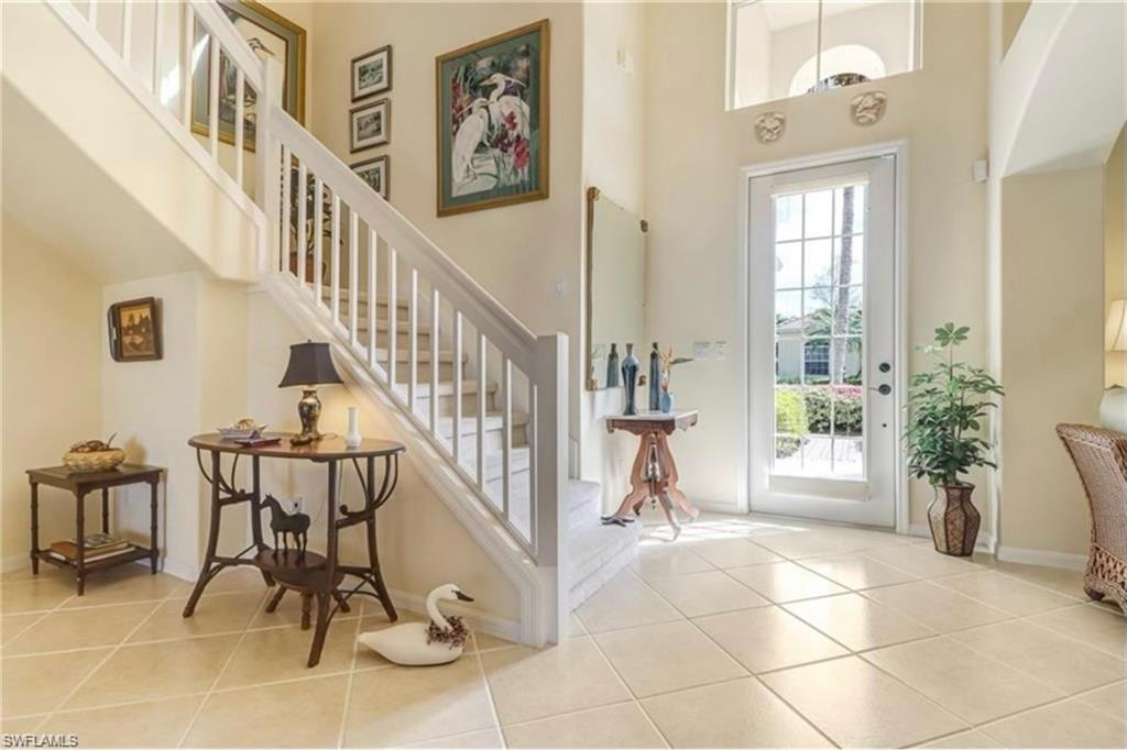 Entrance foyer with light tile patterned floors and a high ceiling