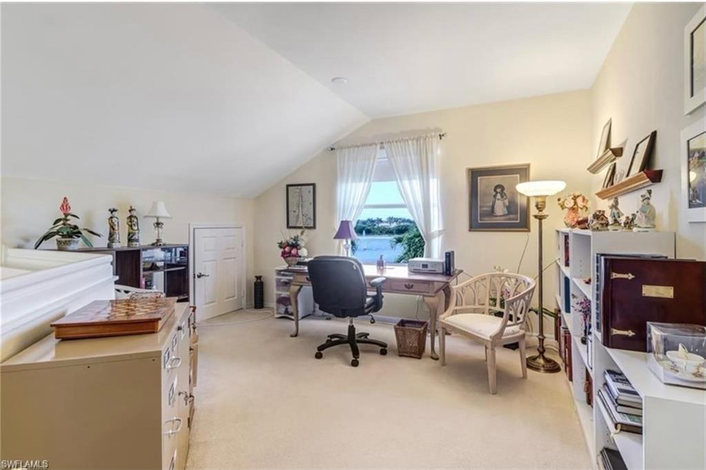 Carpeted office space with vaulted ceiling
