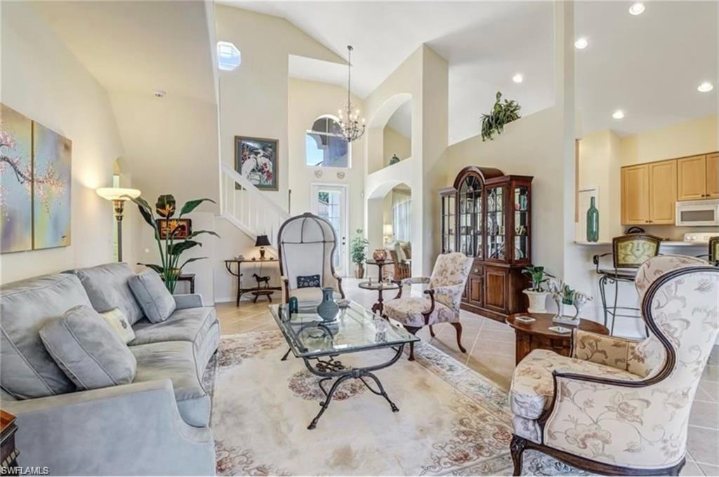 Tiled living room with high vaulted ceiling and an inviting chandelier