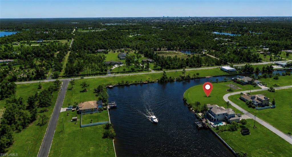Expansive waterfront lot offering direct canal access, a boat dock, and a wide-open grassy area