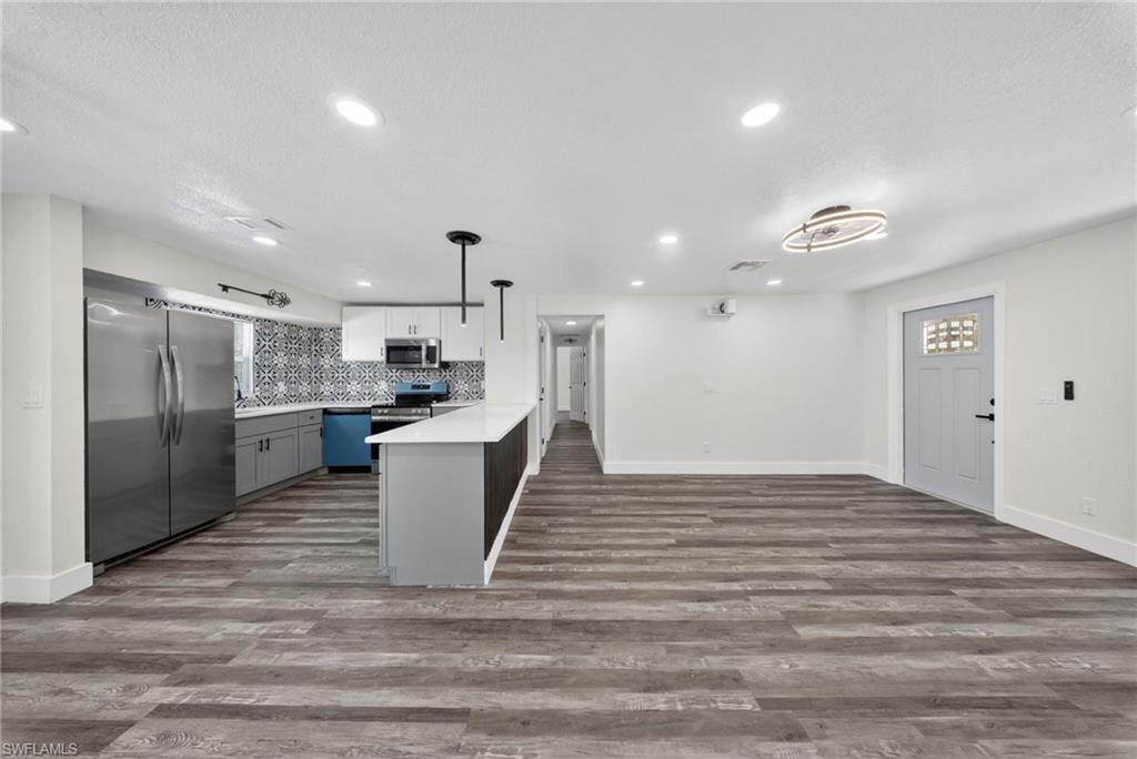 Open-concept living space featuring wood-finish flooring and recessed lighting