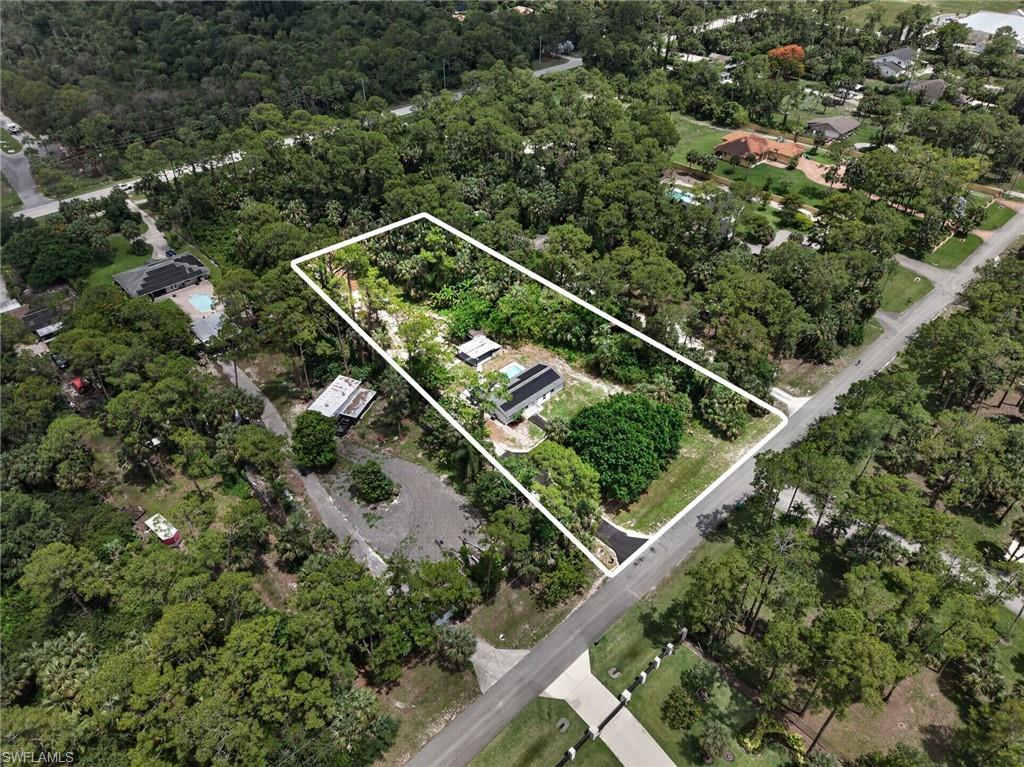 Expansive lot featuring mature trees and a single-story structure with a gray roof