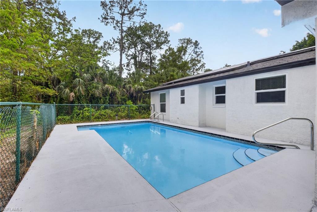 Rectangular pool with integrated steps, concrete decking, and white stucco exterior